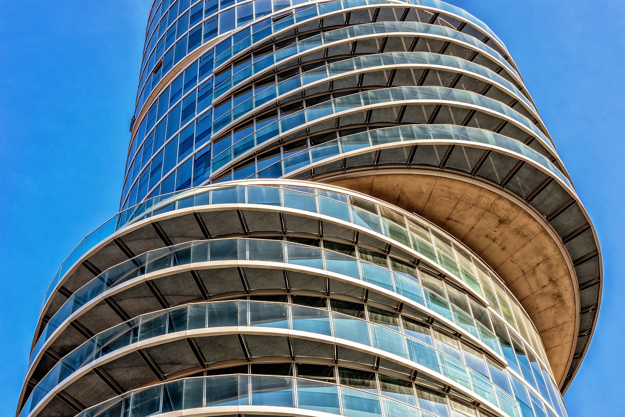 A striking tall building adorned with smooth, curved glass windows, creating a dynamic visual appeal.
