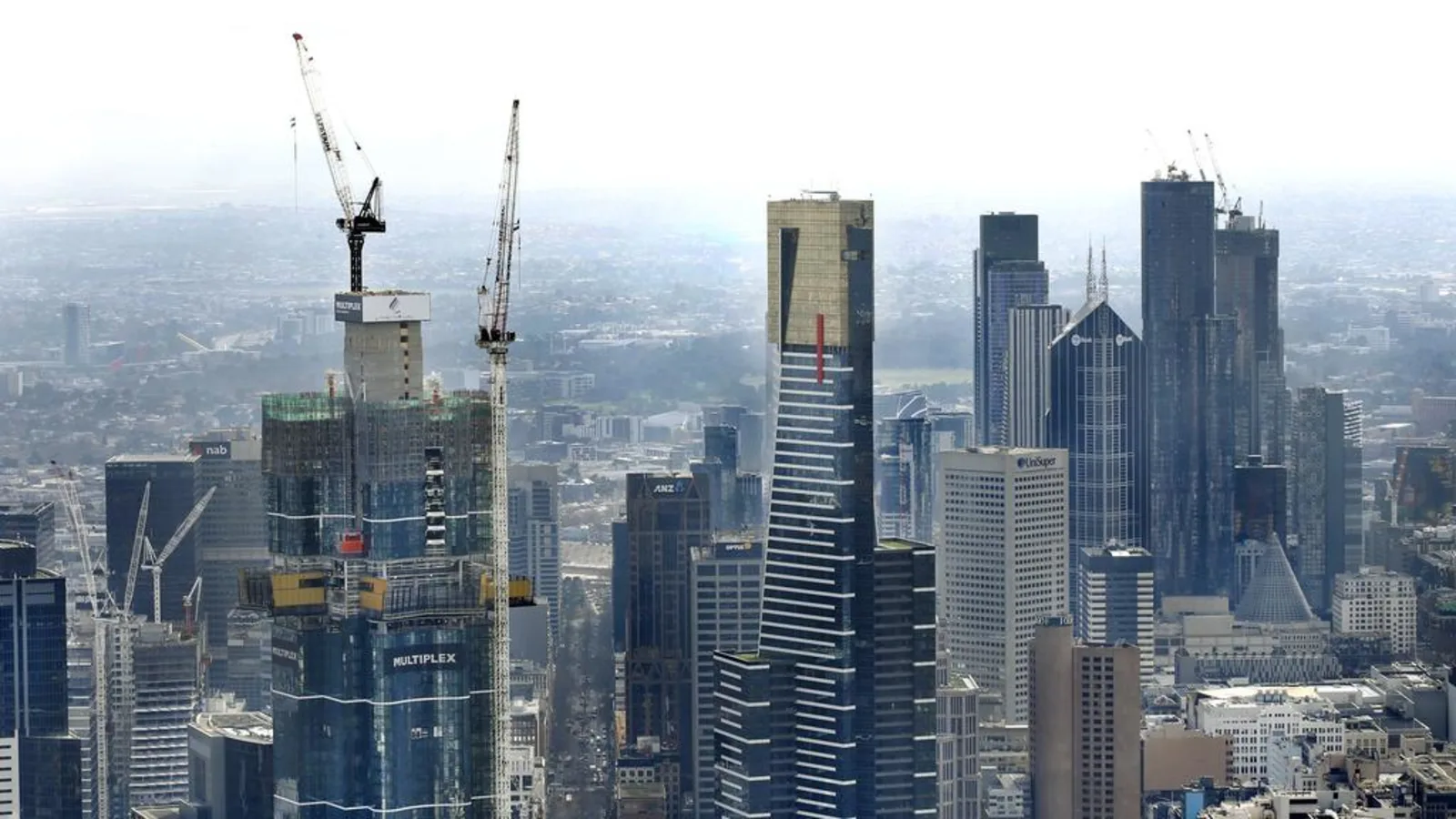 Melbourne city skyline with building cranes in background.