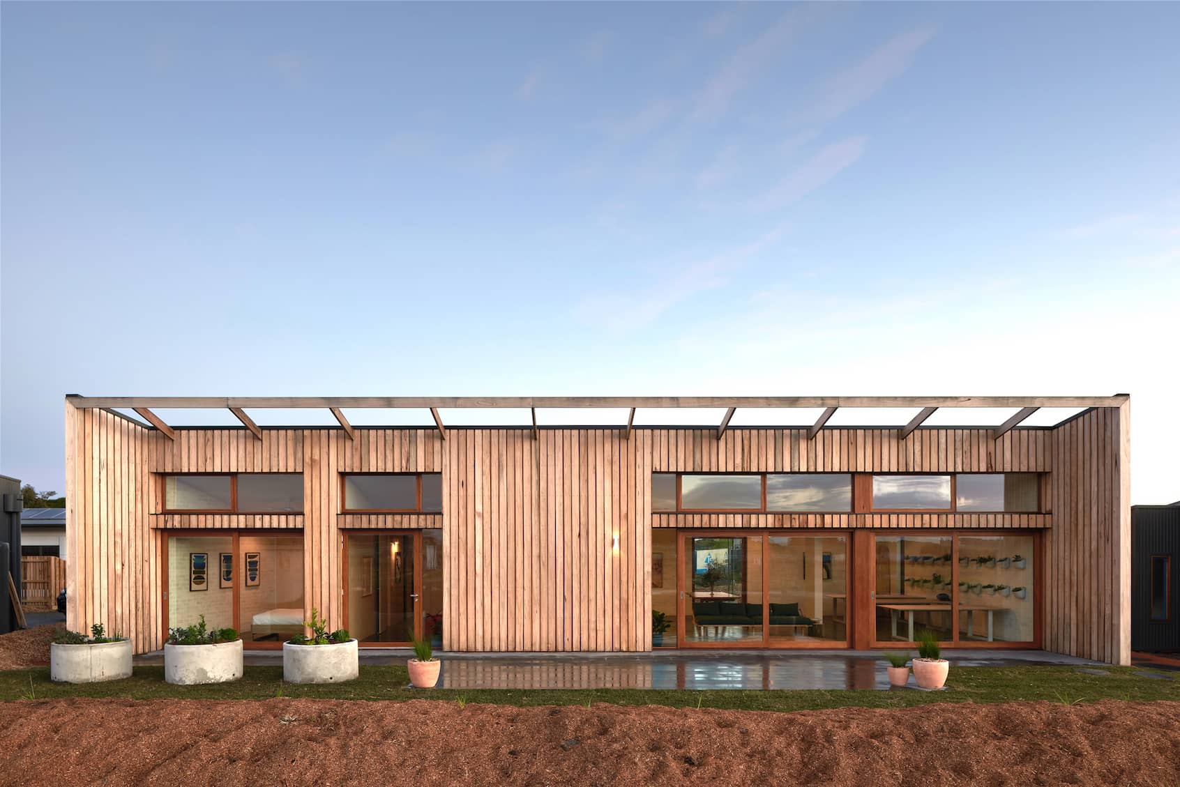A contemporary home featuring wooden siding and a sleek roof design, showcasing modern architectural elements.