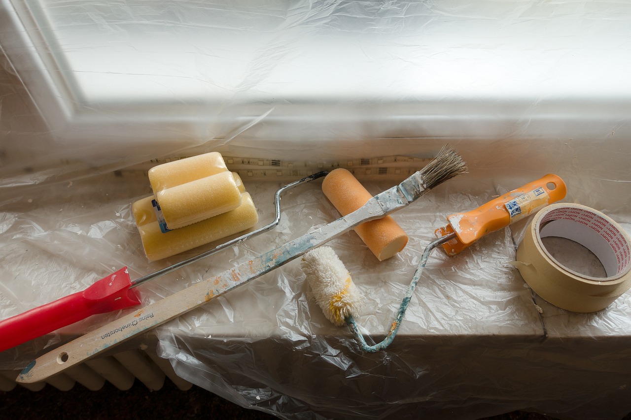 Various painting tools and colourful paint tubes displayed on a window sill, highlighting an property renovation.